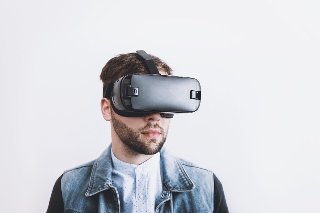 A silhouetted person in a VR headset reaching out into the dark.